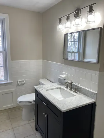 a bathroom with a sink toilet and a mirror