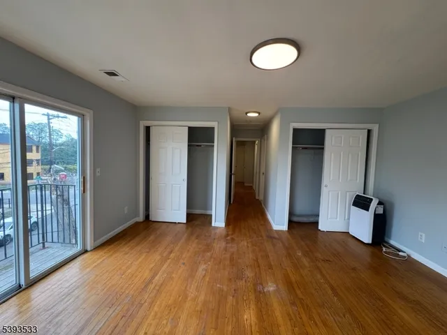 a view of a room with wooden floor and window