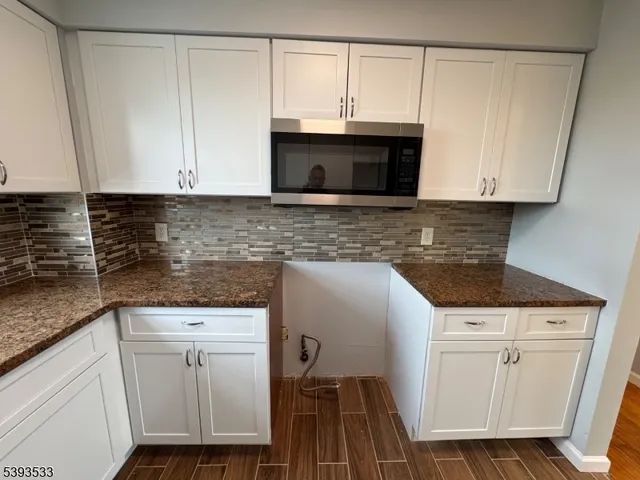 a kitchen with granite countertop a sink and a stove