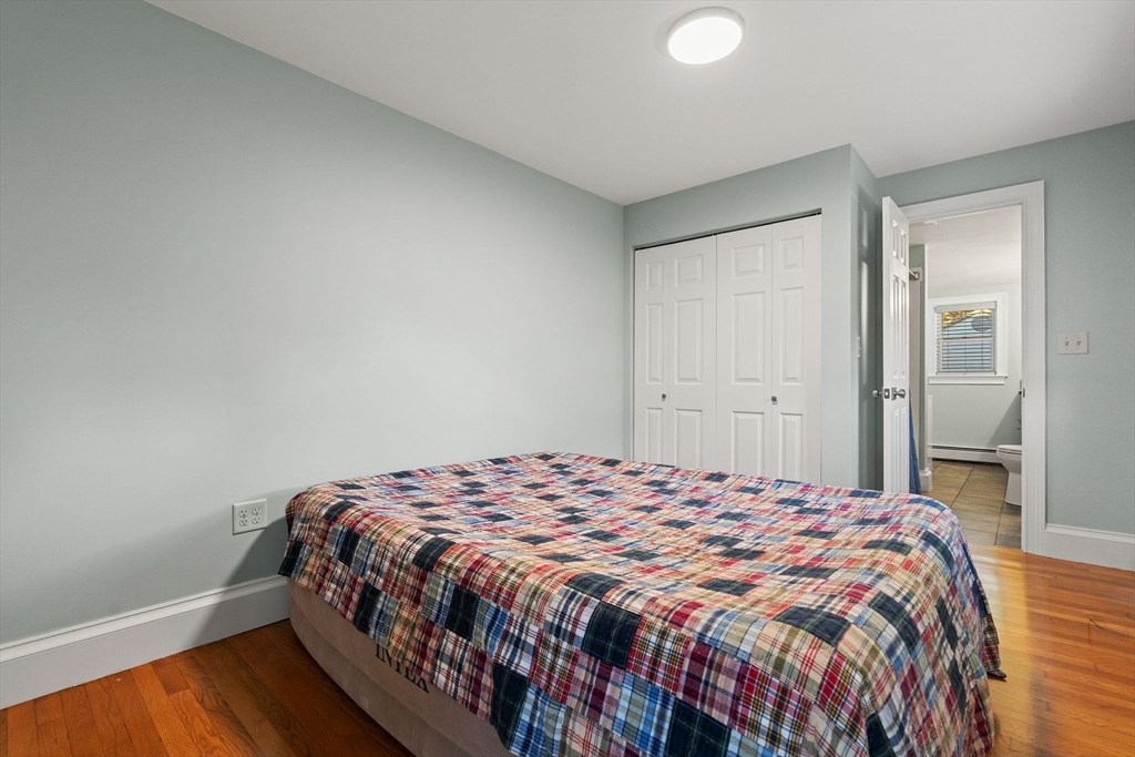 46 Gannett Road Quincy, MA 02169 - Photo 14 of 26 a bedroom with a bed and wooden floor