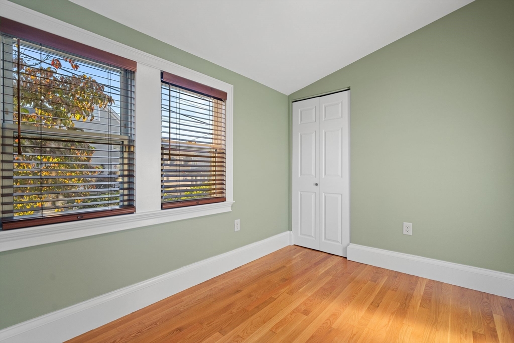 46 Gannett Road Quincy, MA 02169 - Photo 16 of 26 a view of an empty room with wooden floor and a window