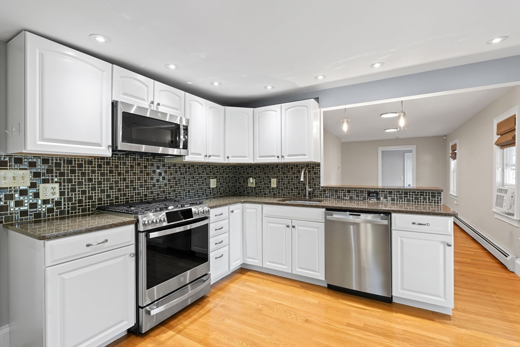 46 Gannett Road Quincy, MA 02169 - Photo 6 of 26 a kitchen with stainless steel appliances granite countertop a sink stove and microwave