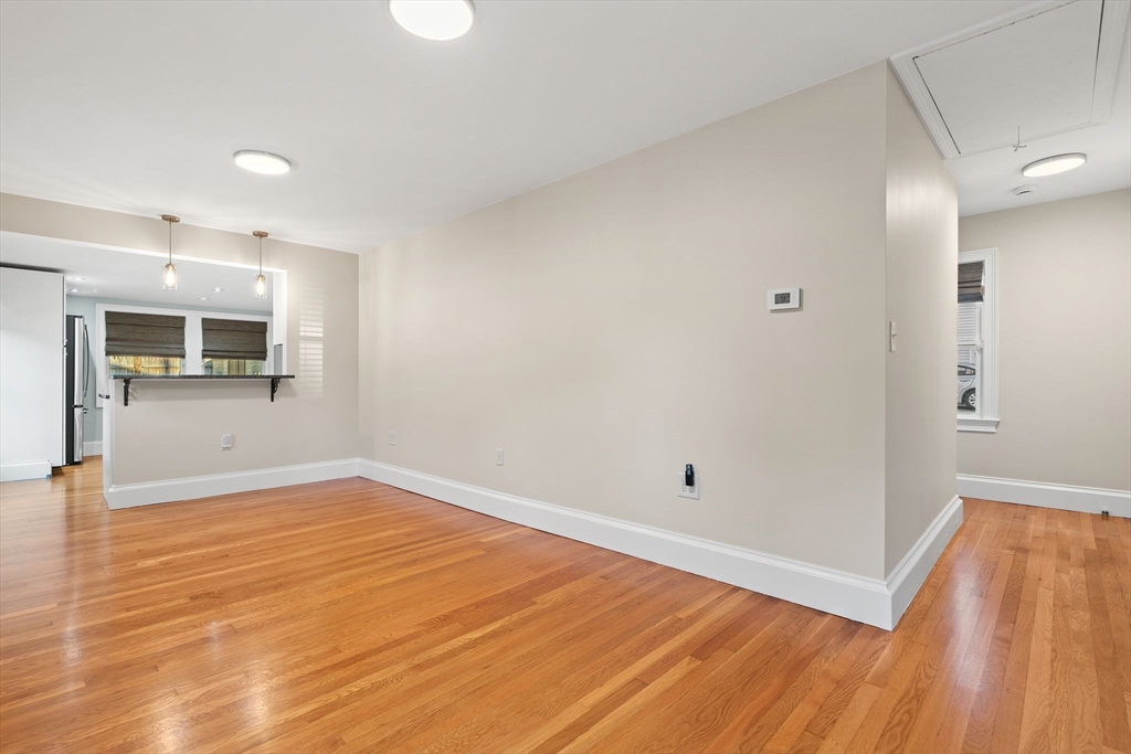 46 Gannett Road Quincy, MA 02169 - Photo 10 of 26 a view of empty room with wooden floor and kitchen view