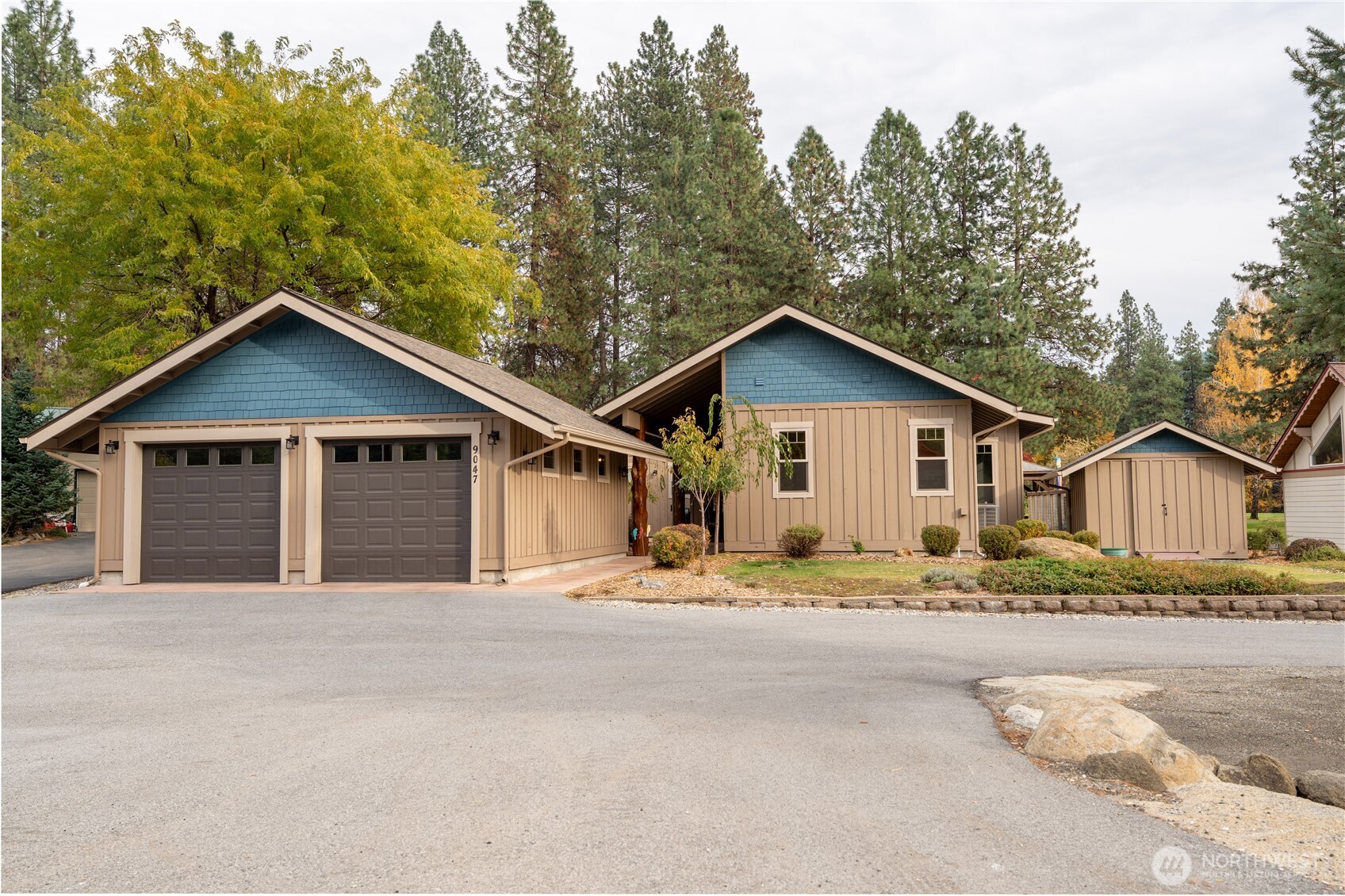 a view of house with outdoor space and trees in the background