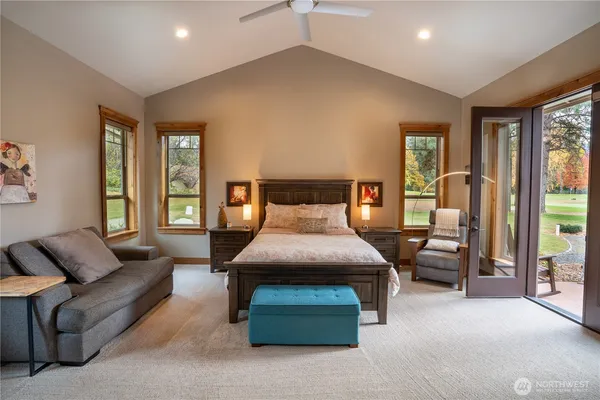 a bedroom with furniture and large windows