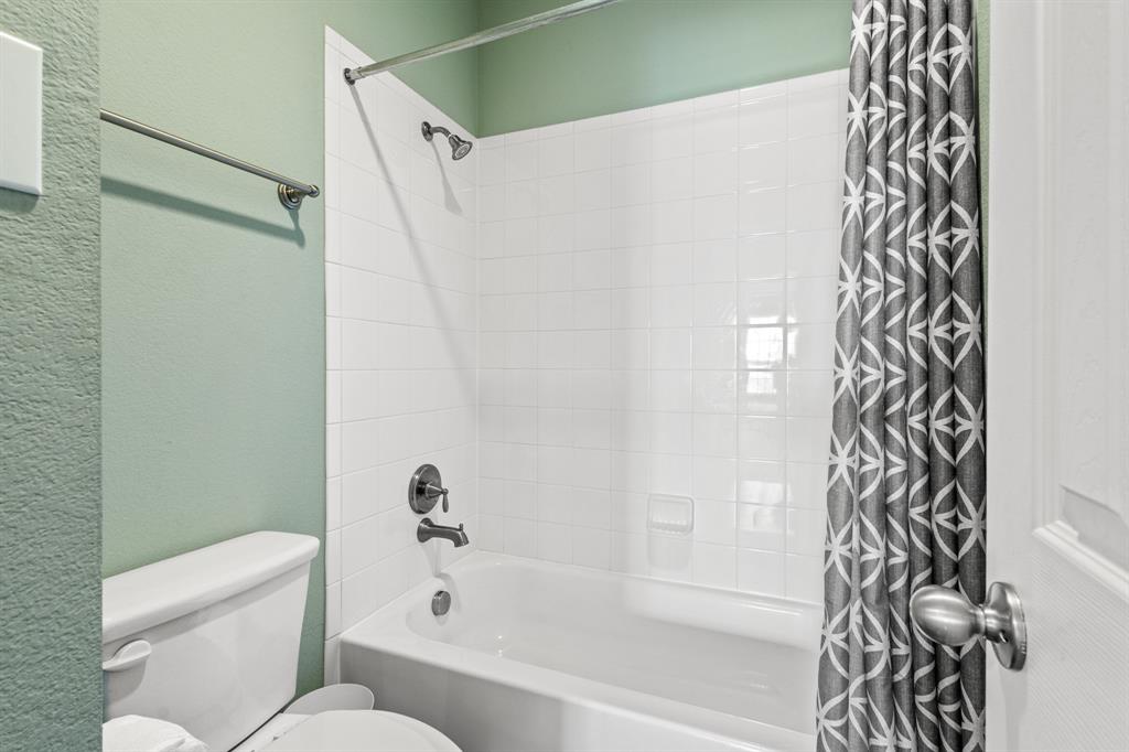 1036 Edgefield Lane Forney, TX 75126 - Photo 25 of 30 a bathroom with a toilet and a shower curtain