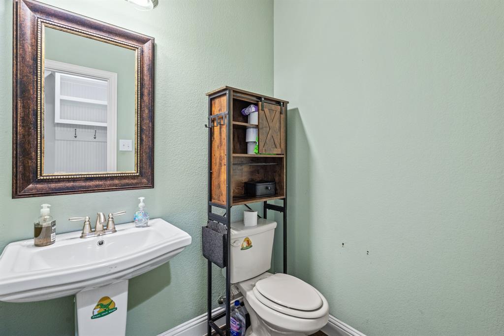 1036 Edgefield Lane Forney, TX 75126 - Photo 9 of 30 a bathroom with a sink a toilet and mirror