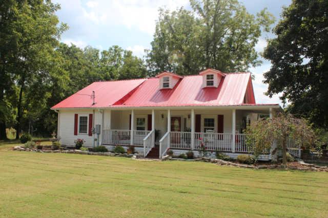 a front view of a house with swimming pool and porch