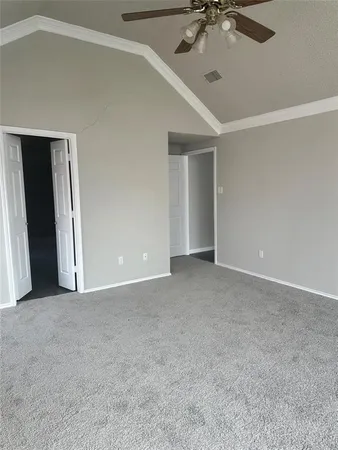 a view of an empty room with a chandelier fan