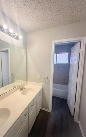 a bathroom with a sink a tub and a mirror