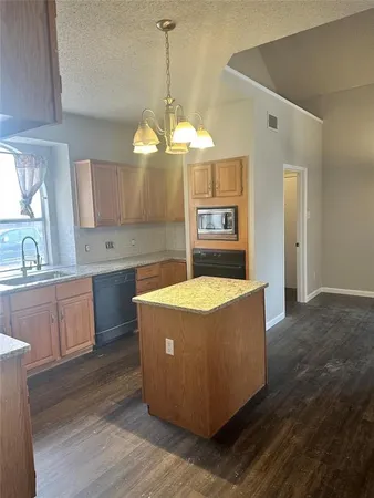 a kitchen with stainless steel appliances granite countertop wooden floors and white walls