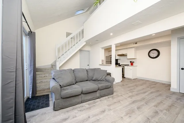a living room with furniture and kitchen view