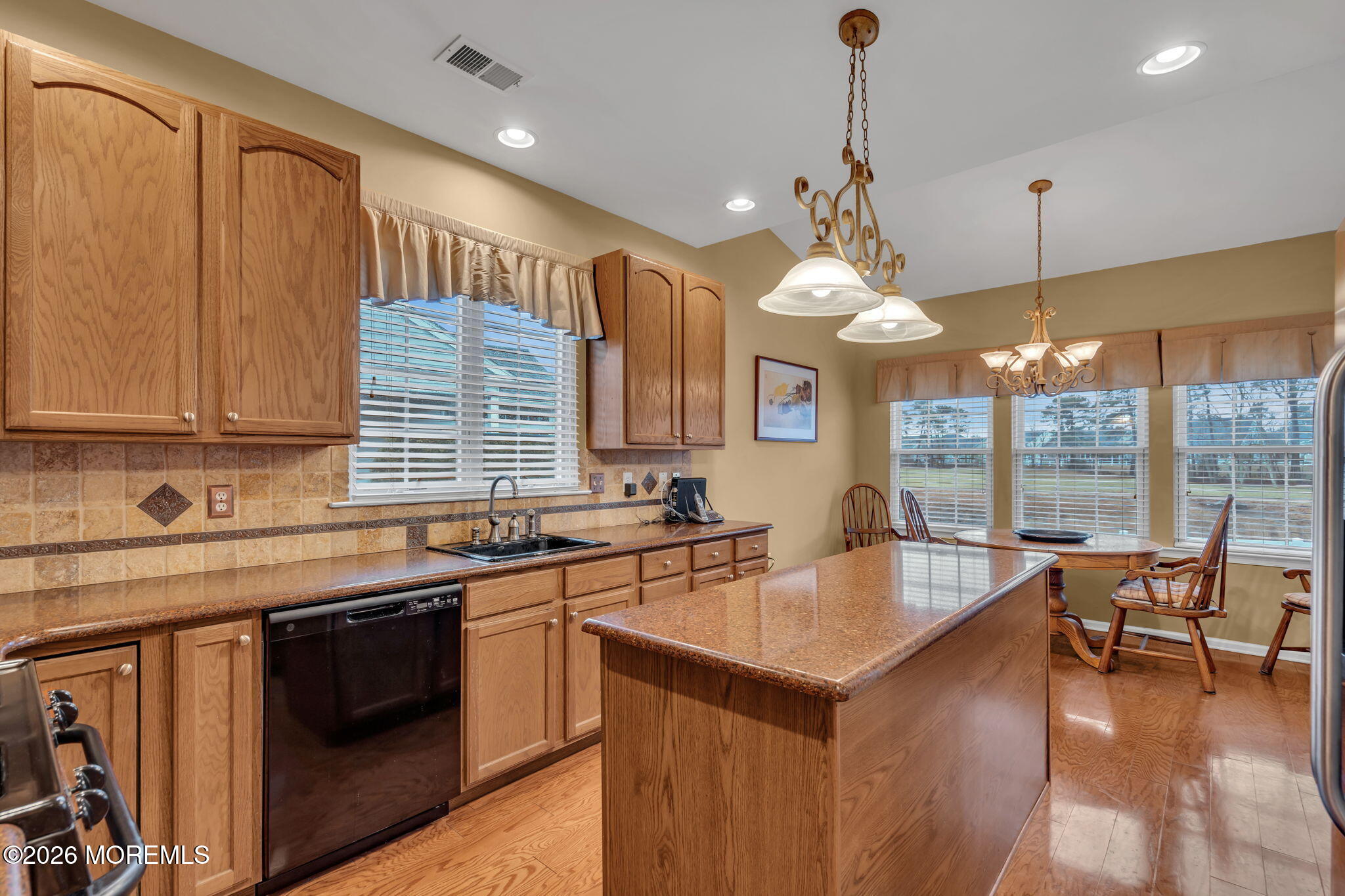 46 Pancoast Road Waretown, NJ 08758 - Photo 13 of 55 a kitchen with a stove a sink dishwasher a dining table chairs and couches with wooden floor
