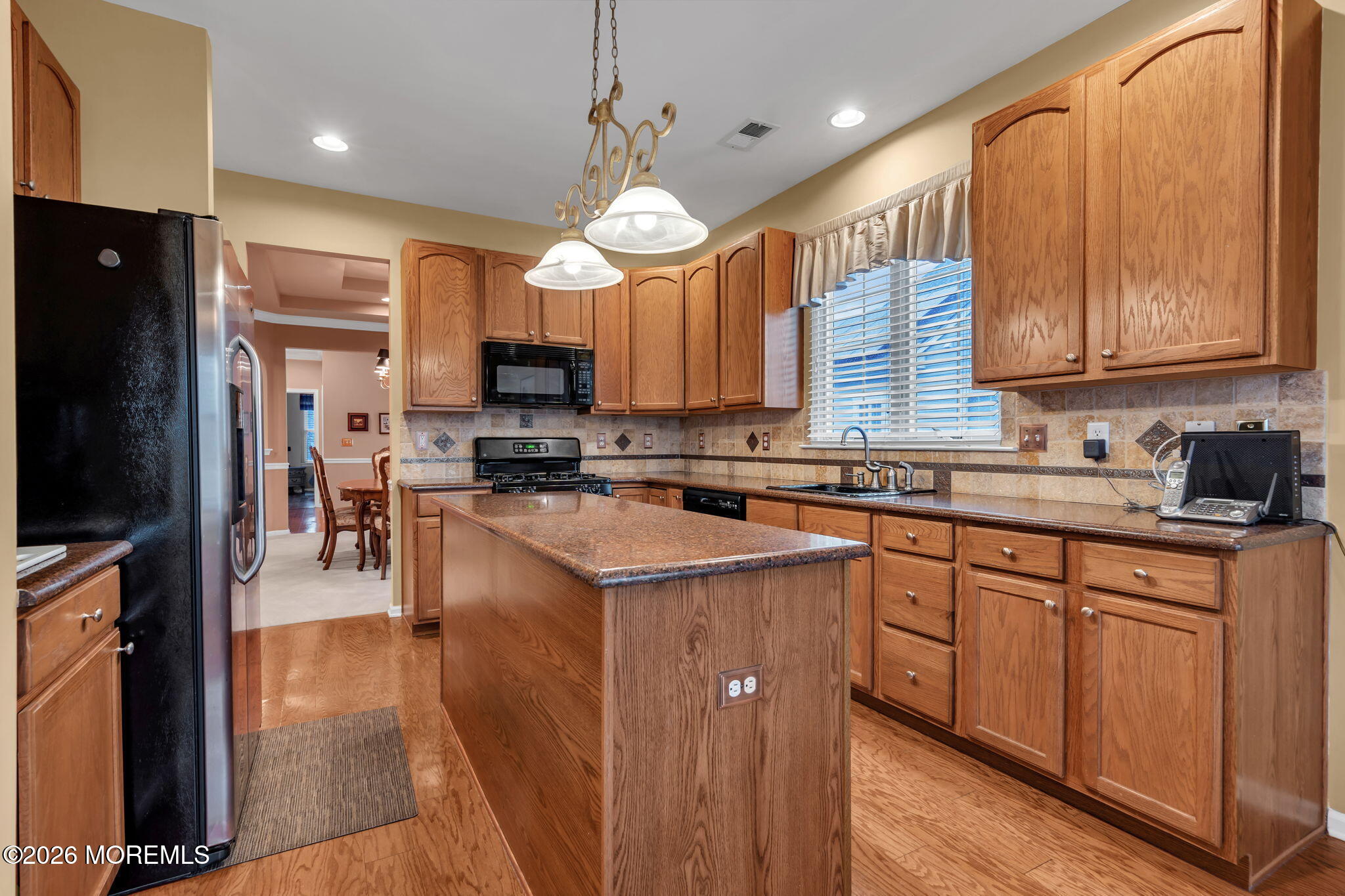 46 Pancoast Road Waretown, NJ 08758 - Photo 15 of 55 a kitchen with stainless steel appliances granite countertop a refrigerator a sink dishwasher a stove a kitchen island and chairs with wooden floor