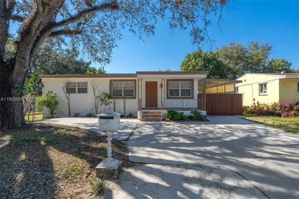 a view of a house with backyard and a tree