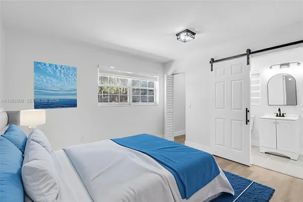 a bedroom with a large bed and a chandelier