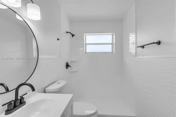 a bathroom with a sink and mirror with toilet