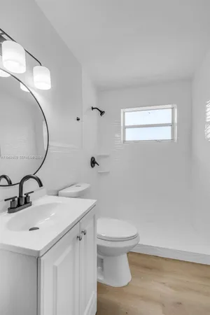 a bathroom with a sink a toilet and mirror