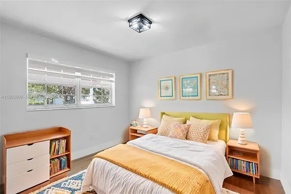 a bedroom with a bed and painting on the wall