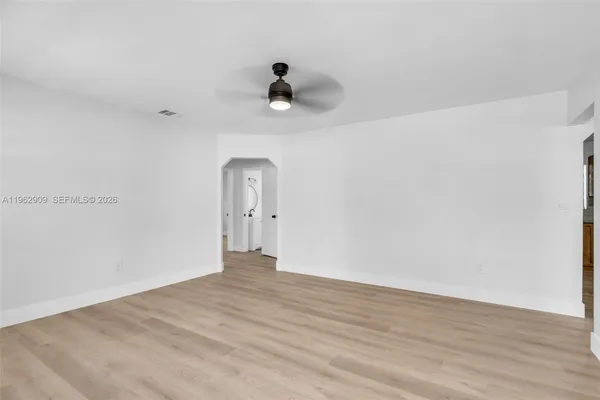 a view of a room with wooden floor and ceiling fan