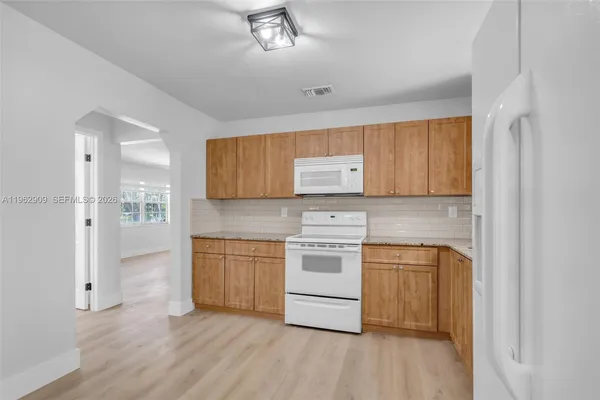 a kitchen with stainless steel appliances granite countertop a stove a sink and a refrigerator