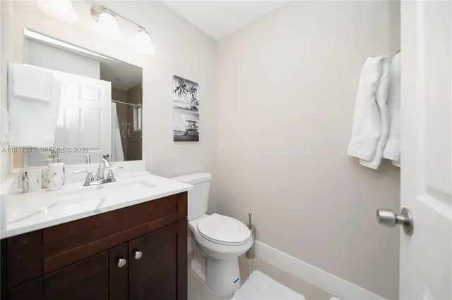 a bathroom with a sink vanity mirror and toilet
