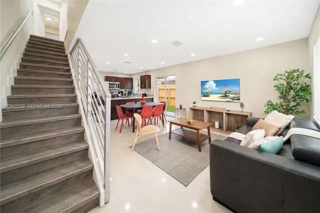 a living room with furniture and stairs