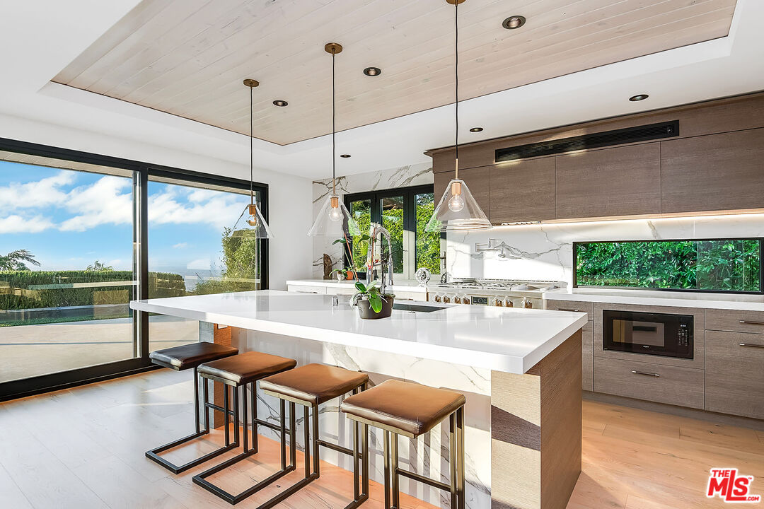 2715 Edwin Place Los Angeles, CA 90046 - Photo 16 of 52 a kitchen with stainless steel appliances granite countertop a stove and a view of living room with a large window