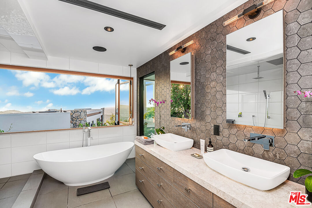 2715 Edwin Place Los Angeles, CA 90046 - Photo 22 of 52 a bathroom with a double vanity sink a mirror and a bathtub