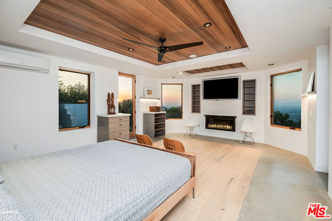 2715 Edwin Place Los Angeles, CA 90046 - Photo 42 of 52 a spacious bedroom with a large bed and a fireplace