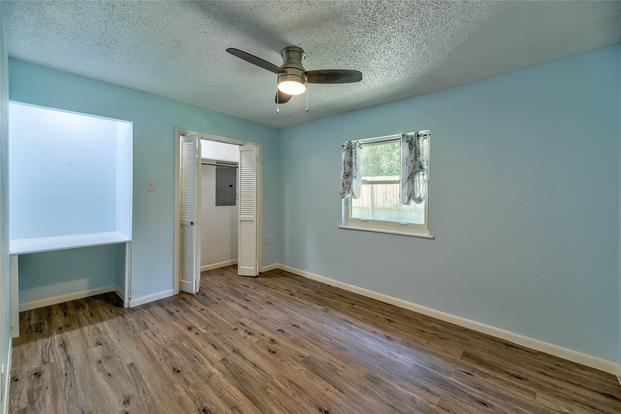 3003 Paul Knox Street Huntsville, TX 77320 - Photo 19 of 46 an empty room with wooden floor chandelier and windows