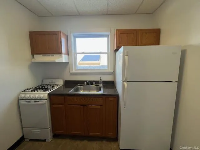 a kitchen with a refrigerator sink stove and cabinets