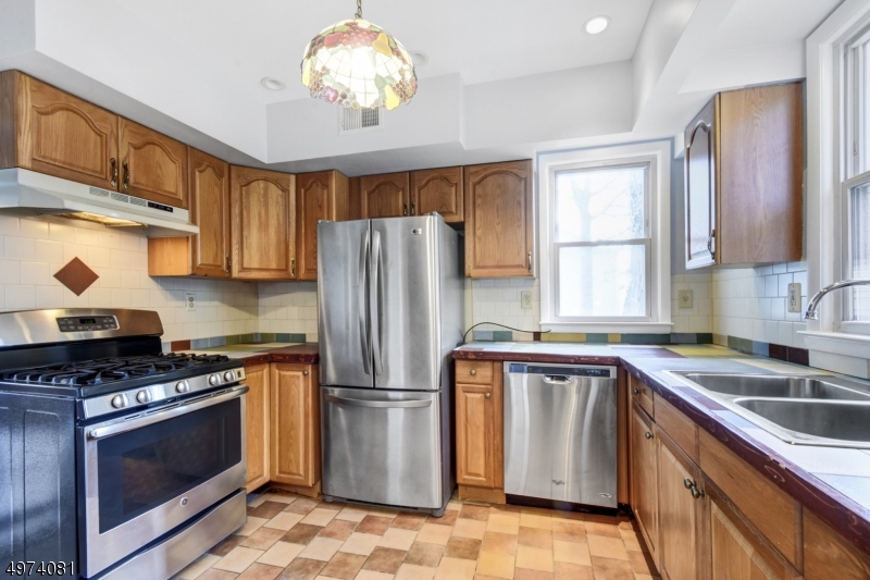 558 Summit Avenue, Unit 1 Westfield, NJ 07090 - Photo 8 of 13 a kitchen with a stove a sink and a refrigerator