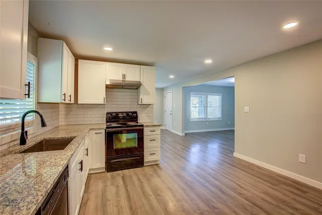 a kitchen with granite countertop a stove and a sink