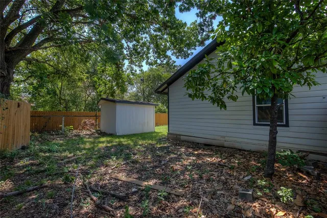 a backyard of a house with lots of plants and trees