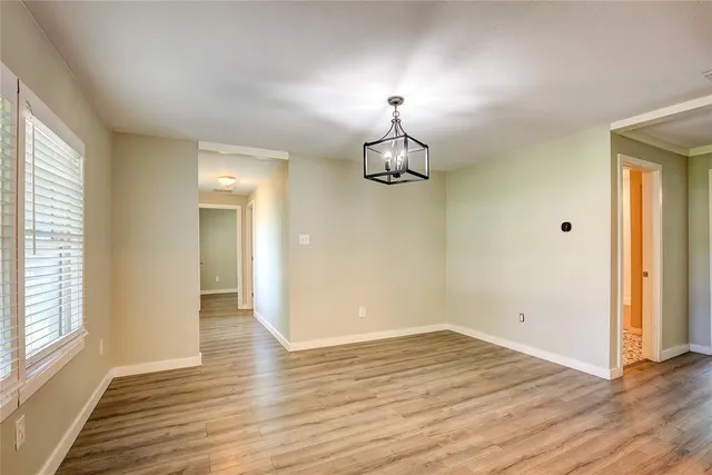 an empty room with wooden floor and window