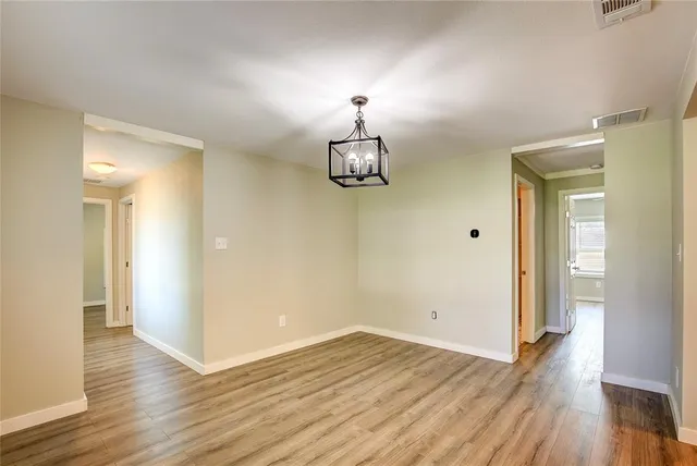 wooden floor chandelier and closet in a room