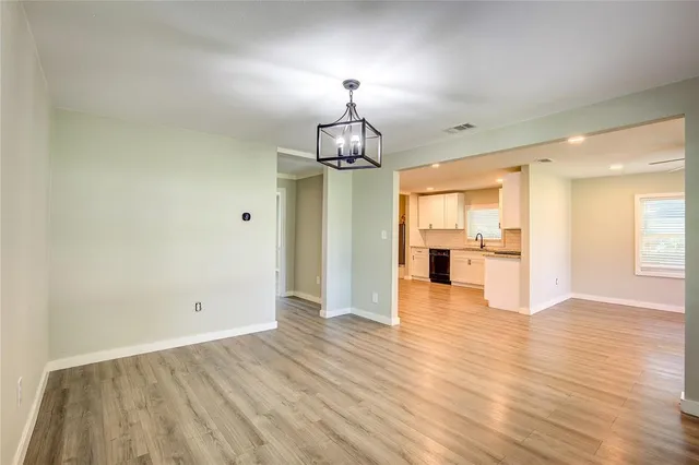 a view of a livingroom with wooden floor a kitchen space with a kitchen