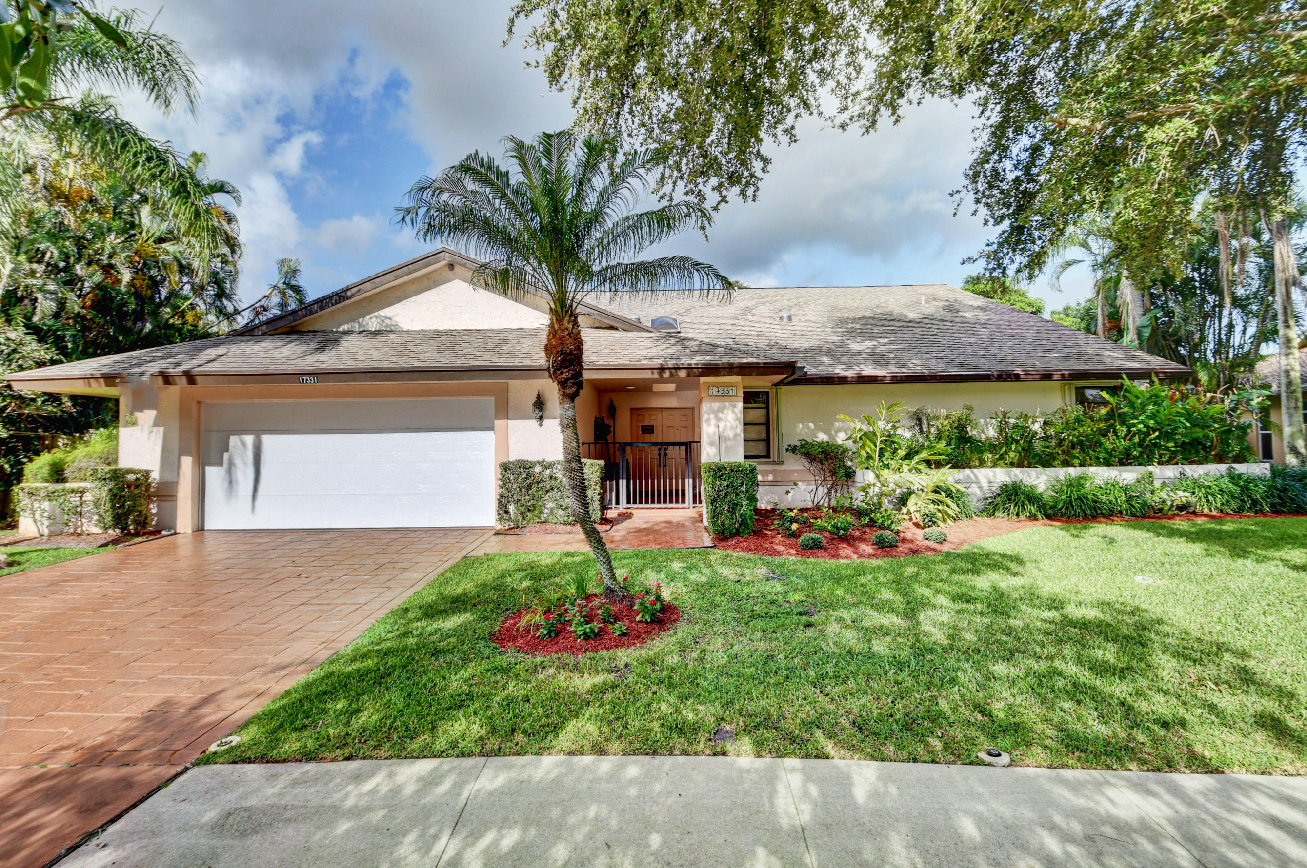 17331 Springtree Lane Boca Raton, FL 33487 - Photo 2 of 60 a front view of a house with a garden and patio