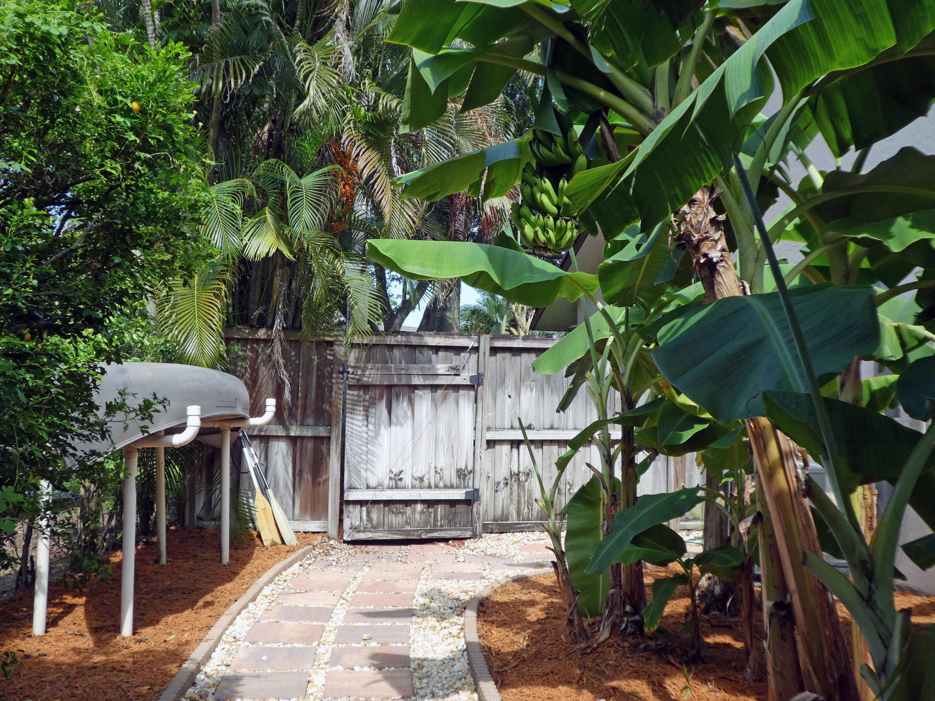 17331 Springtree Lane Boca Raton, FL 33487 - Photo 46 of 60 a backyard of a house with barbeque oven table and chairs