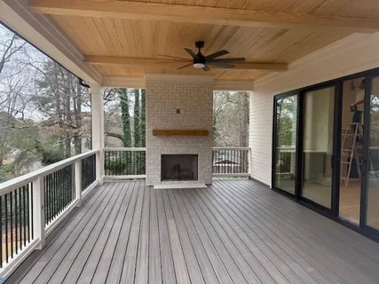 a view of an empty room with wooden floor fireplace and a window