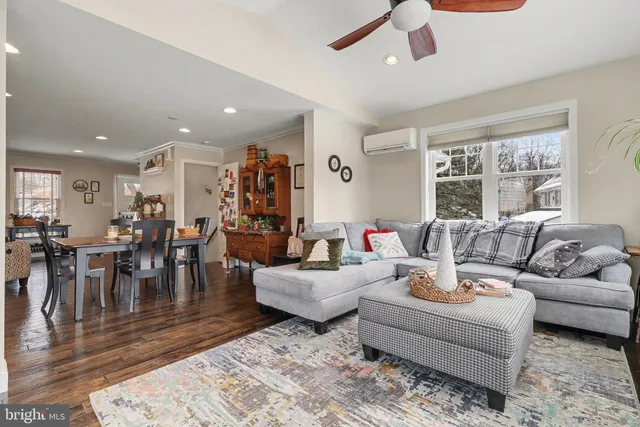 a living room with furniture wooden floor and a large window