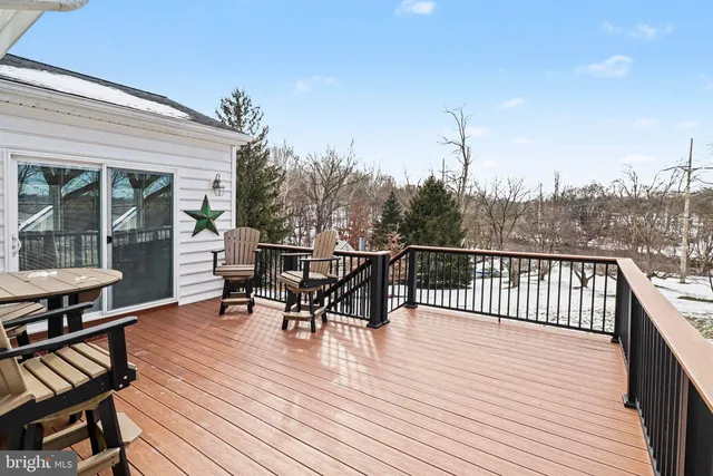 a view of a roof deck with table and chairs with wooden floor and fence
