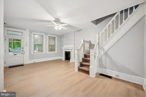 an empty room with windows and fireplace