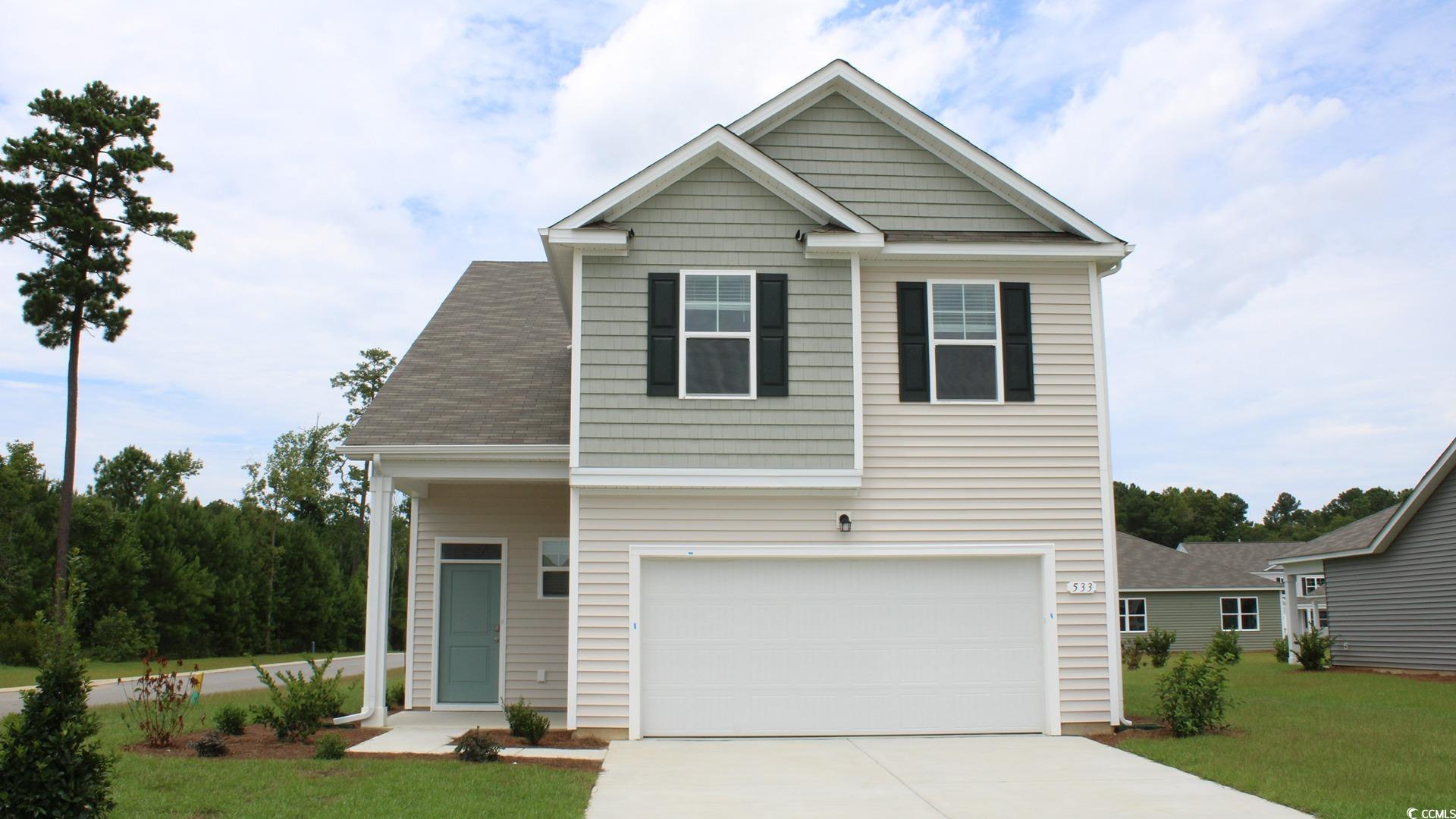 Craftsman-style house with a front lawn, driveway, a garage, and a shingled roof