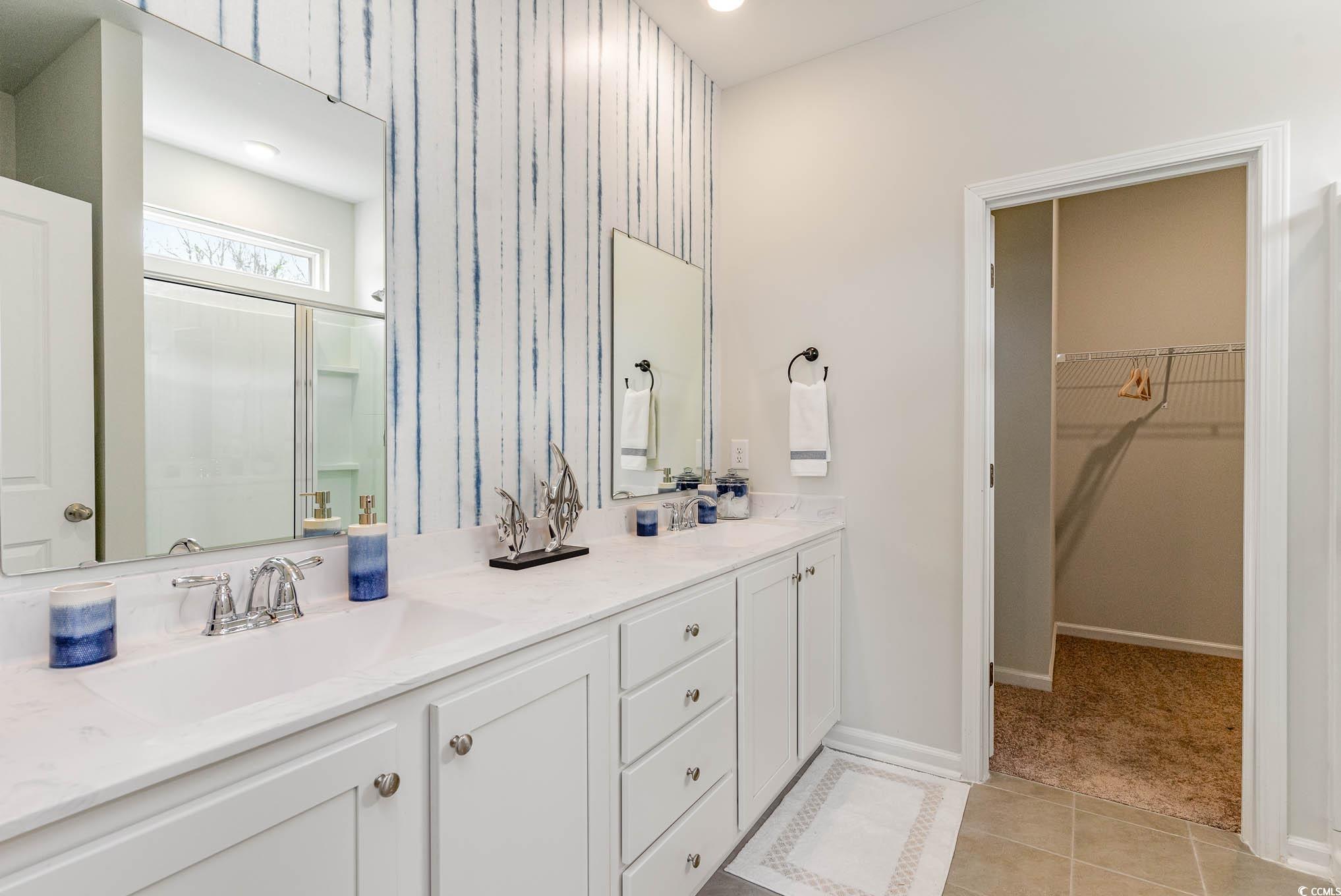629 Anthem Court Conway, SC 29527 - Photo 16 of 40 Bathroom featuring a shower stall, light tile patterned floors, a spacious closet, double vanity, and light carpet