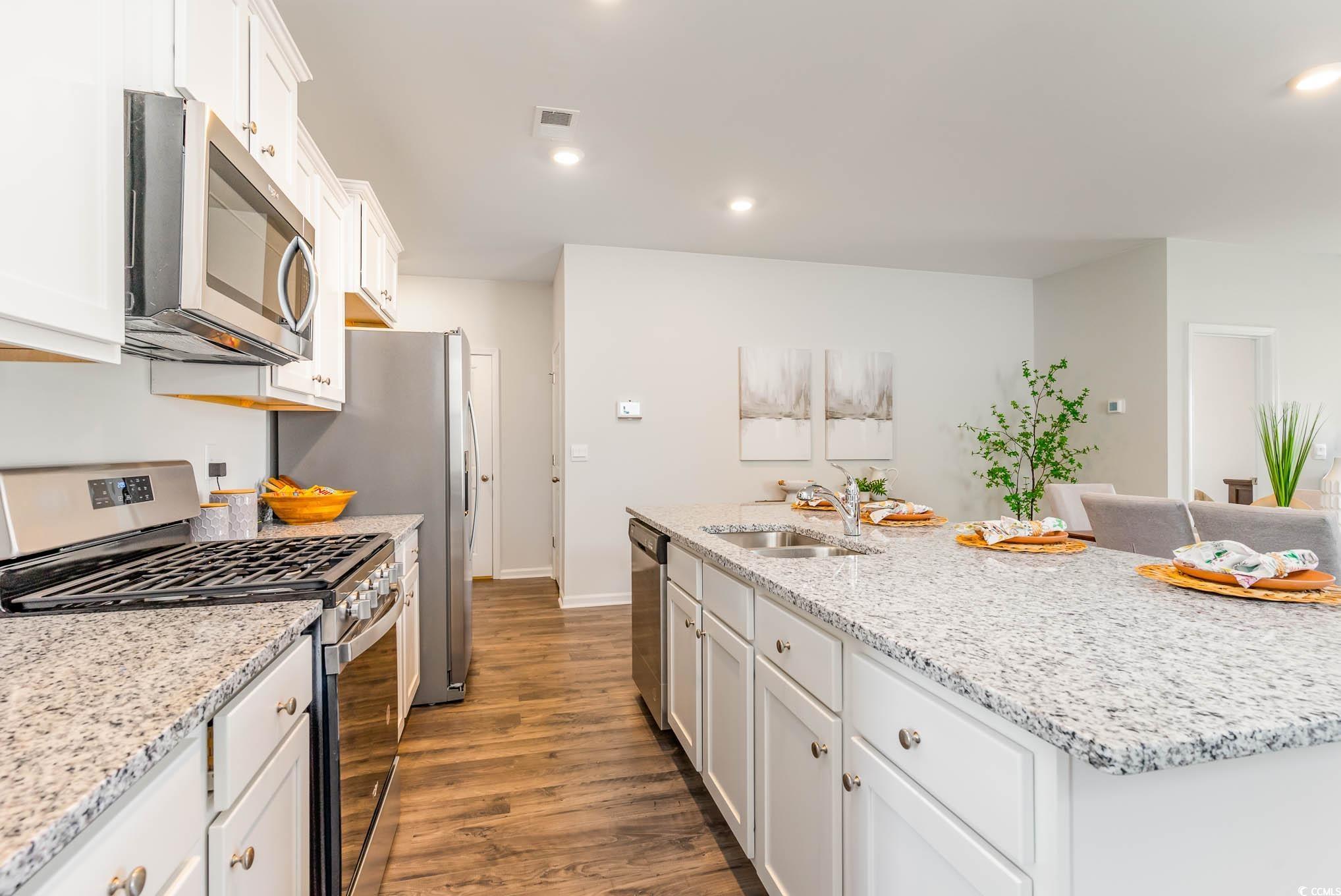 629 Anthem Court Conway, SC 29527 - Photo 7 of 40 Kitchen with appliances with stainless steel finishes, white cabinetry, dark wood finished floors, light stone counters, and recessed lighting