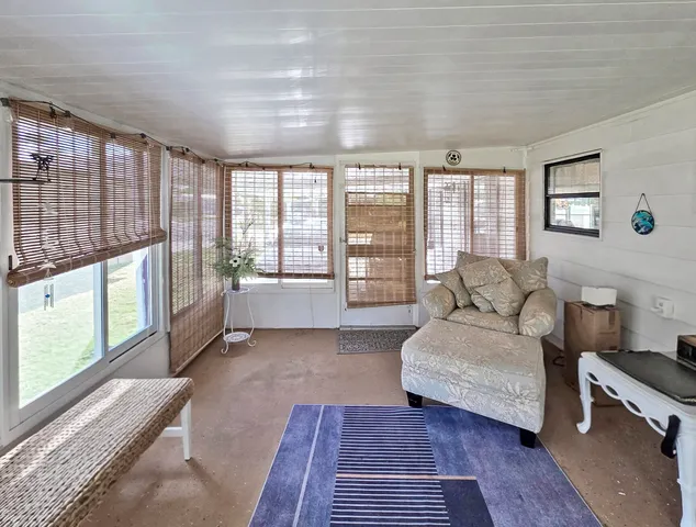 a living room with furniture and a floor to ceiling window