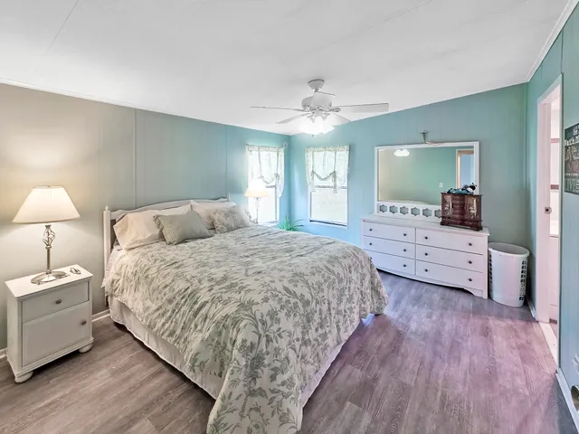 a spacious bedroom with a large bed and a chandelier