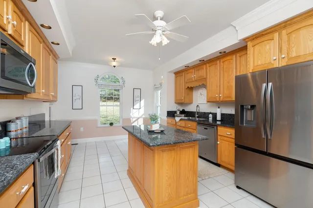 a kitchen with stainless steel appliances granite countertop wooden cabinets a stove top oven a sink and dishwasher